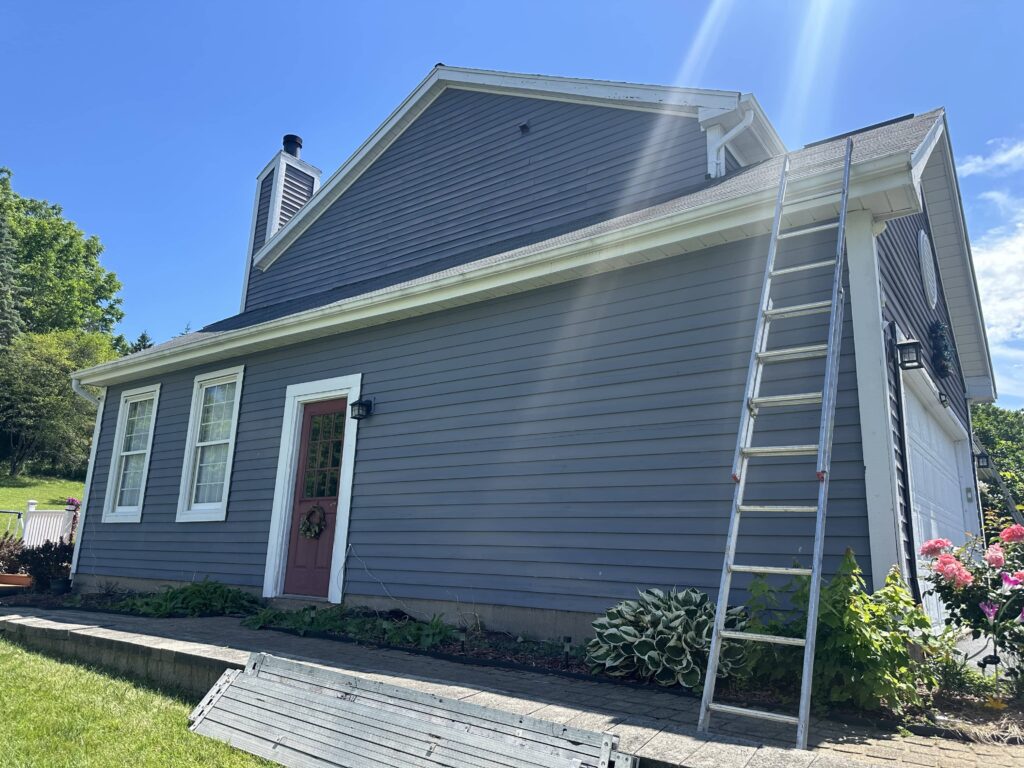 a ladder on a house with Jesse James Home Museum in the background