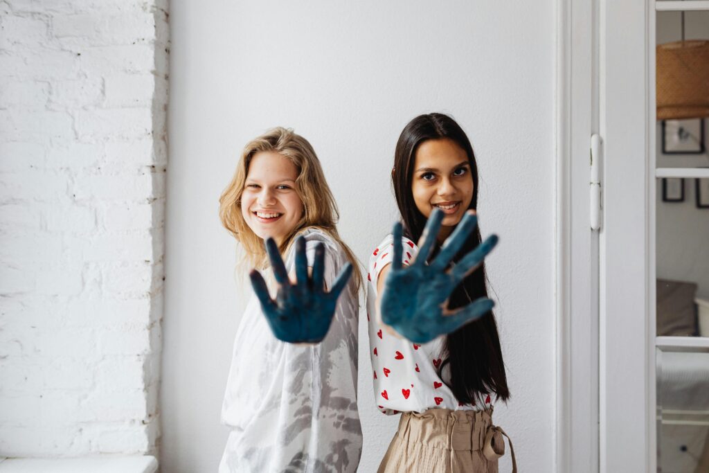 two girls wiht eco-friendly paint on there hands