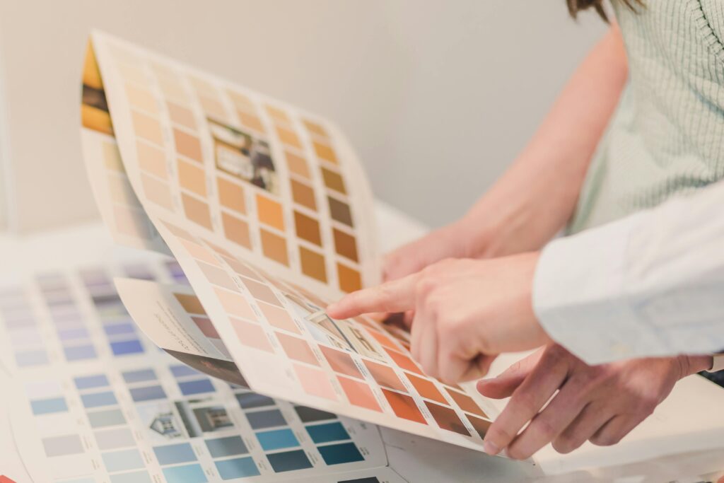 A man and woman looking over a swatch of neutral colors.